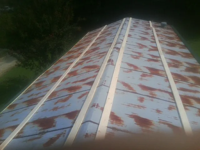 Rusted metal roof panels with new wood purlins before replacement — Storm Damage Roof Repair in Malta by Roofing Brothers